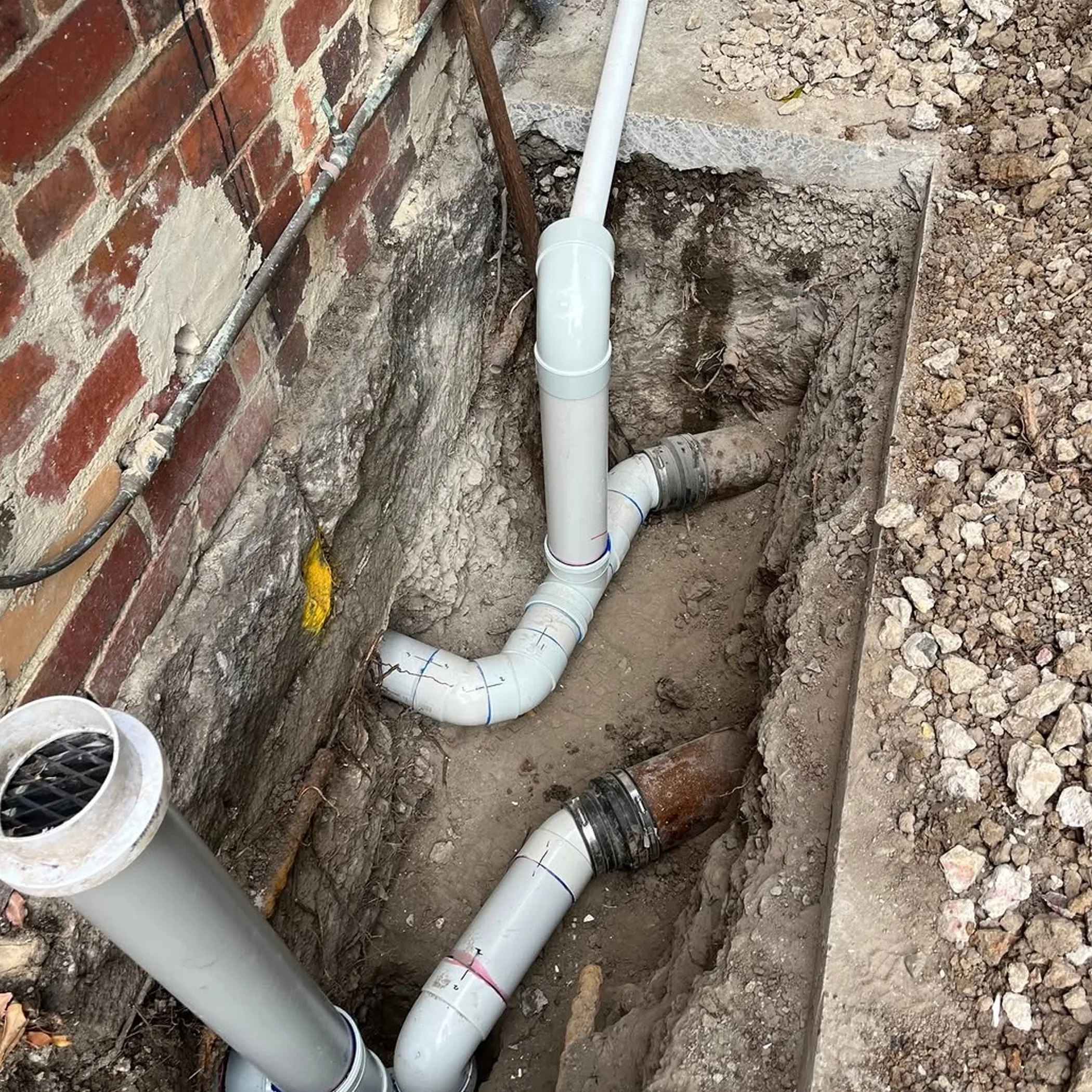 plumbing and drainage work by old brick home